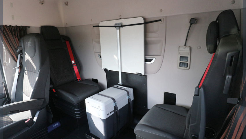 Une cabine de camion équipée de deux sièges perpendiculaires et d'aménagements modulables