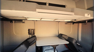 Une cabine équipée de sièges perpendiculaires et d'une couchette pour un espace optimisé
